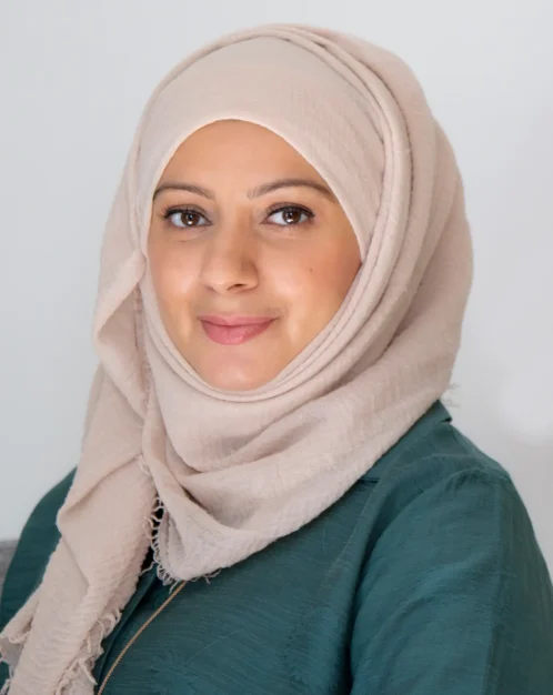 Friendly portrait of a counsellor Bina wearing a light headscarf.